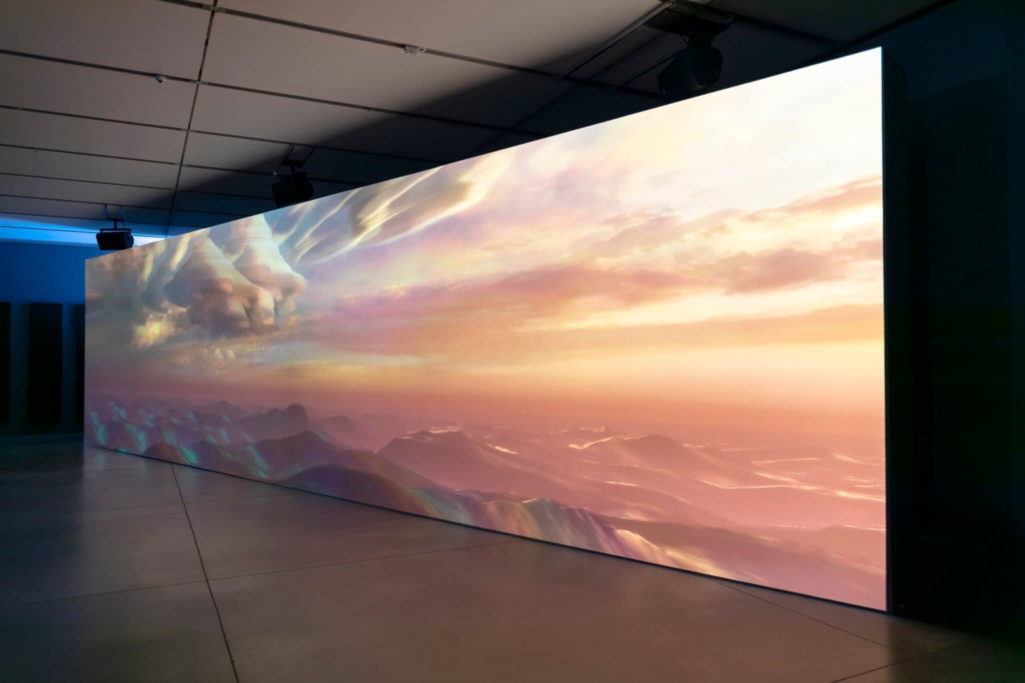 A colorful, sunlit sky, filled with billowing clouds, above crashing waves.