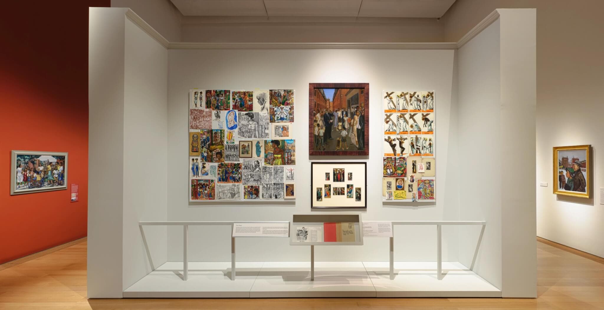 Paintings and collages centered on a white gallery wall.